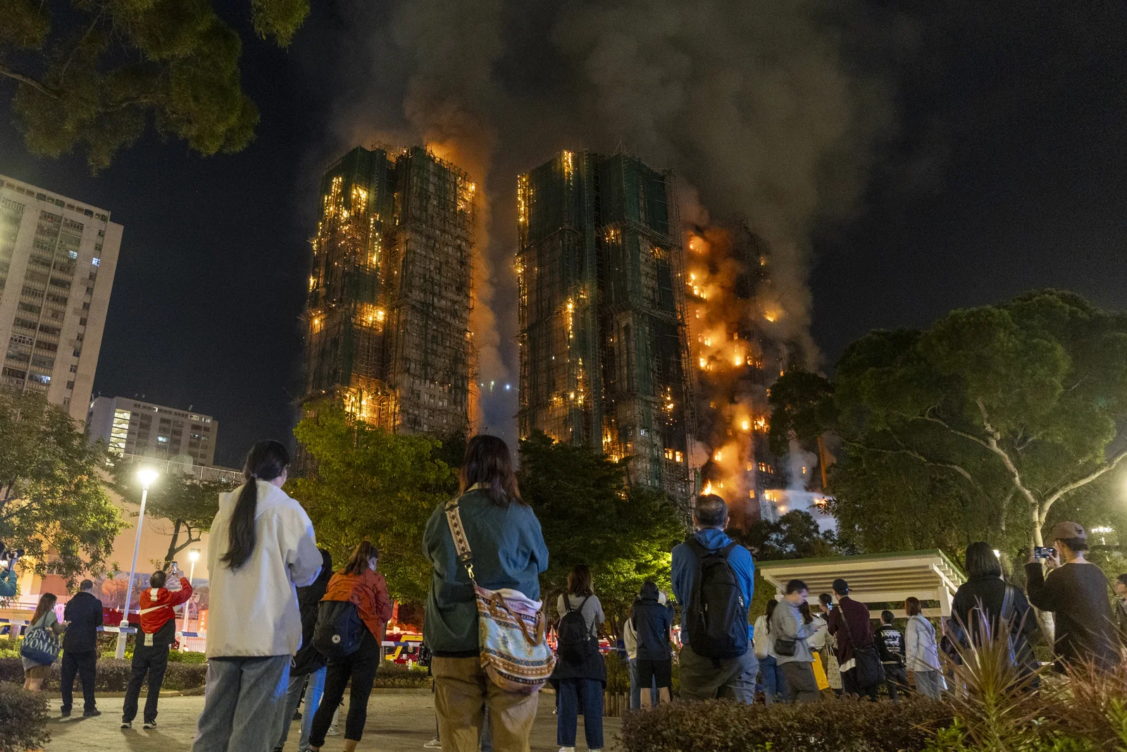 People watching the burning towers of Wang Fuk Court at night in Tai Po, Hong Kong