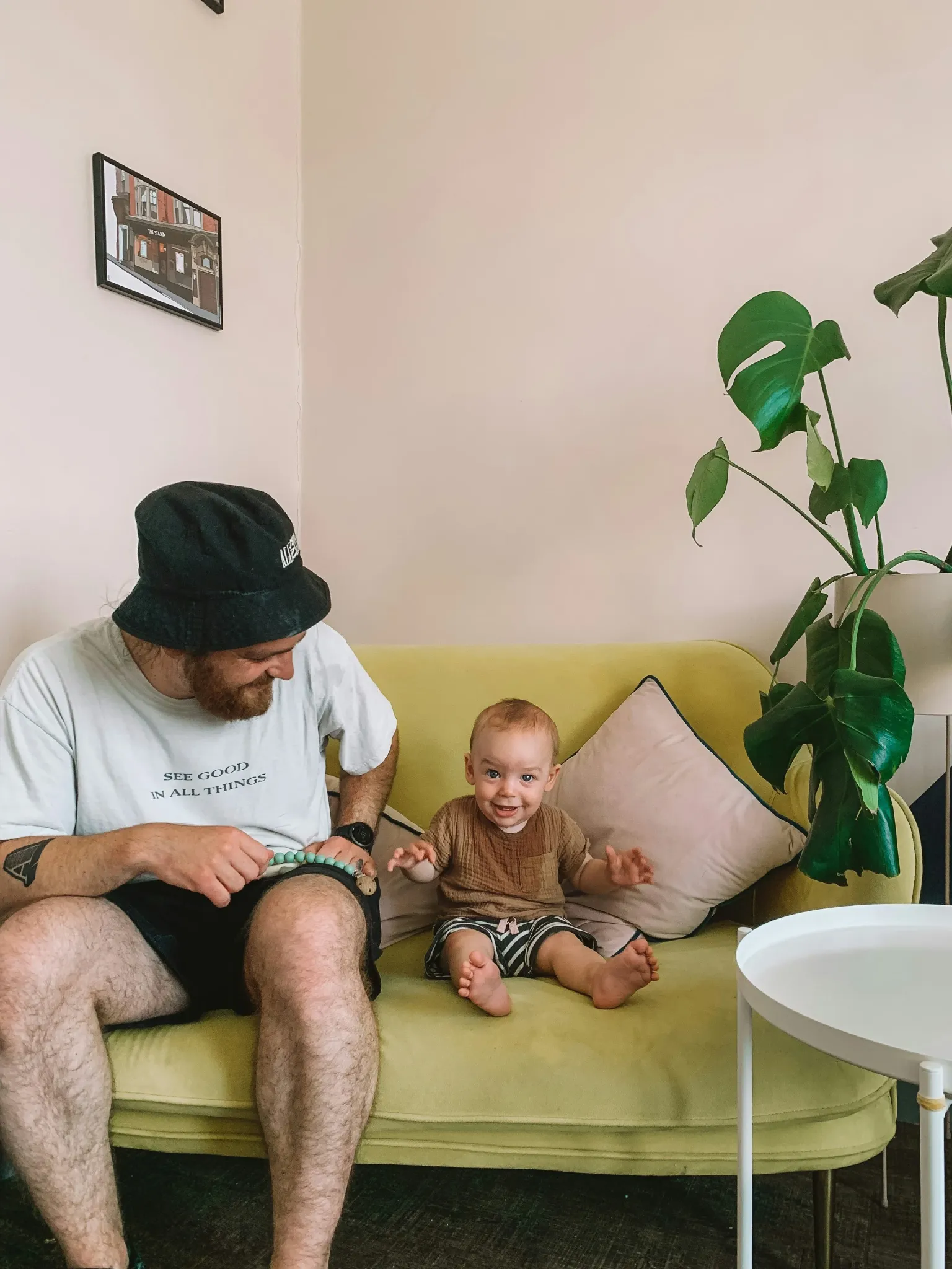 An adult and a child seated on a yellow sofa in an image published by USHS